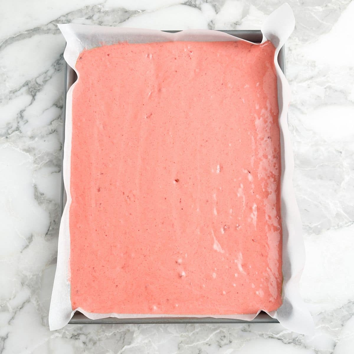 Sheet pan with strawberry cake batter.