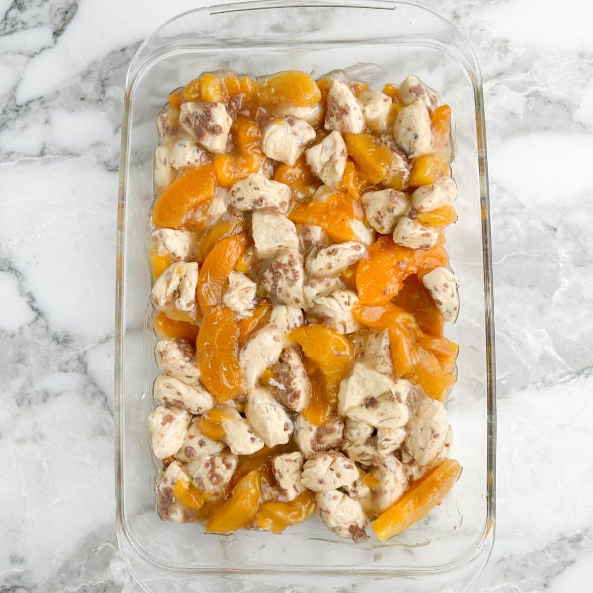 Casserole dish with cinnamon roll peach cobbler.