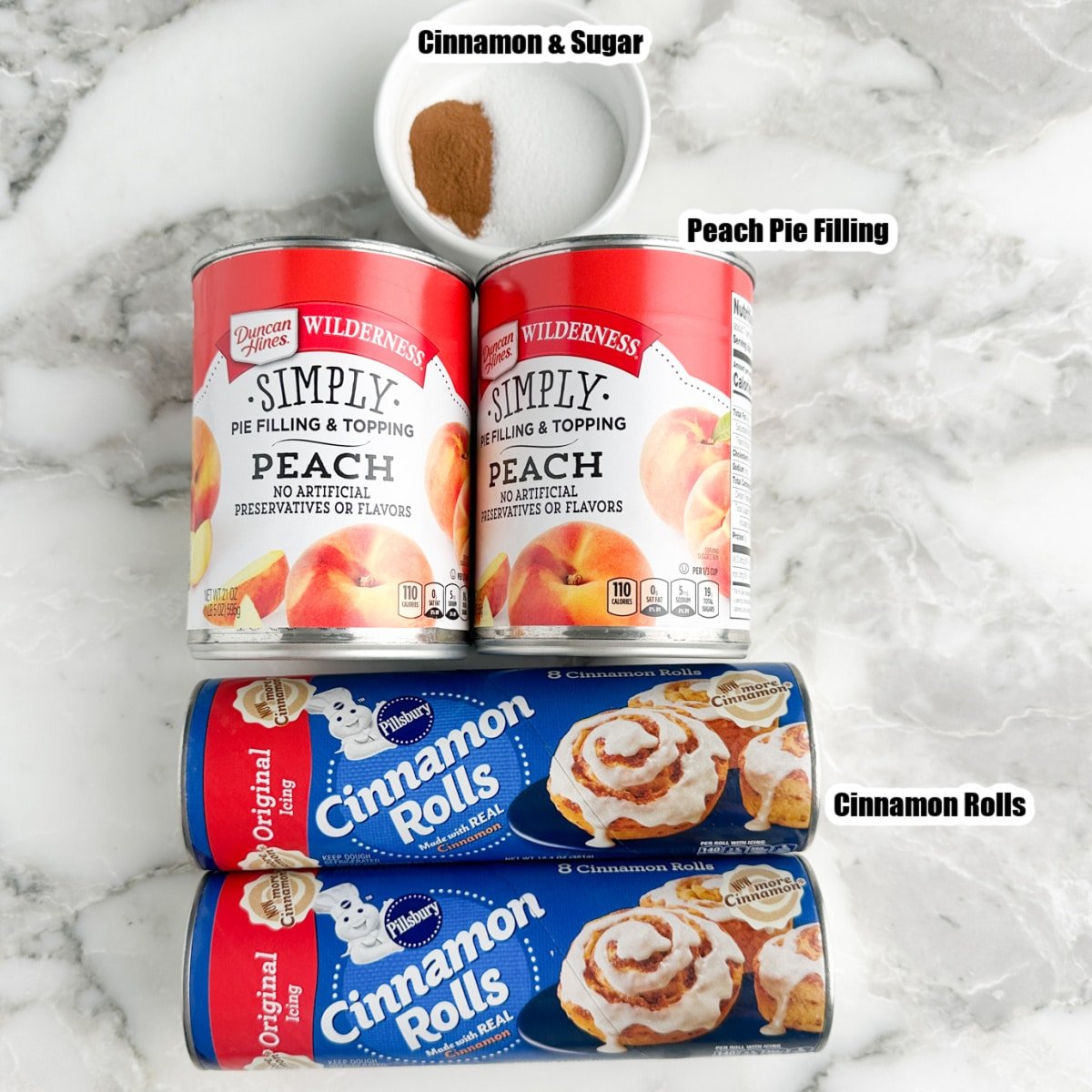 Cans of cinnamon rolls, cans of peach pie filling, bowl of cinnamon and sugar.