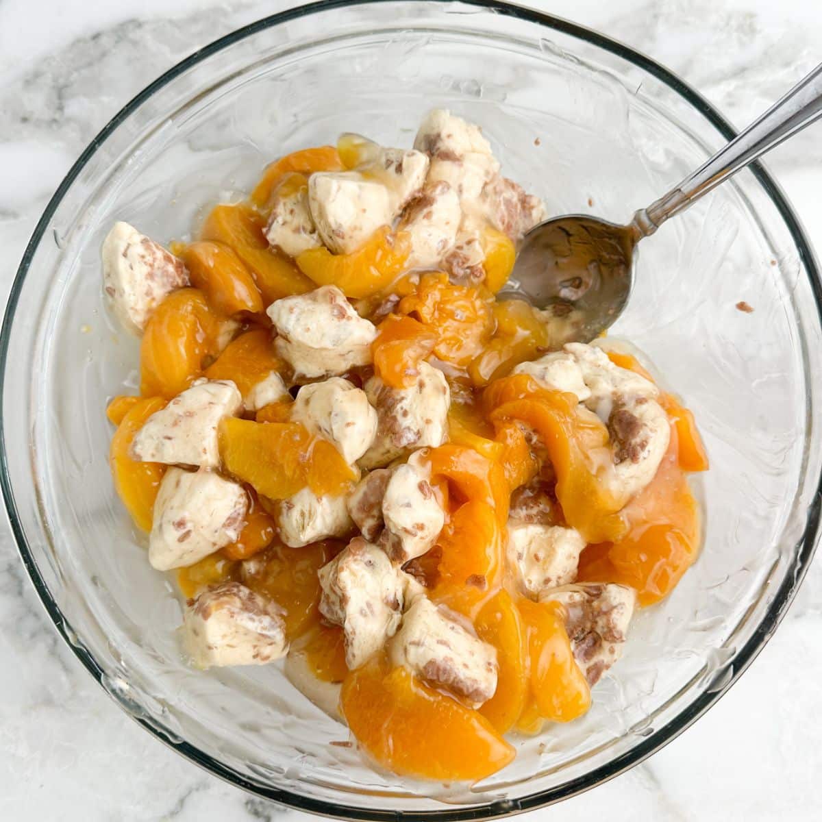 Bowl of cinnamon rolls with peach pie filling.