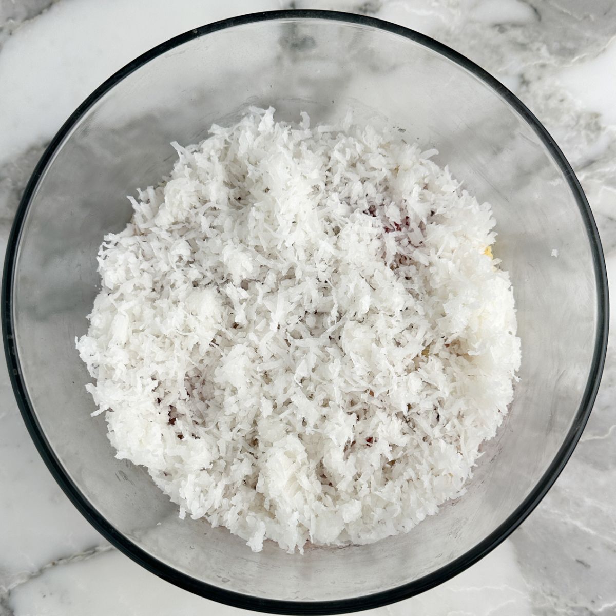 Glass bowl with cake and shredded coconut.