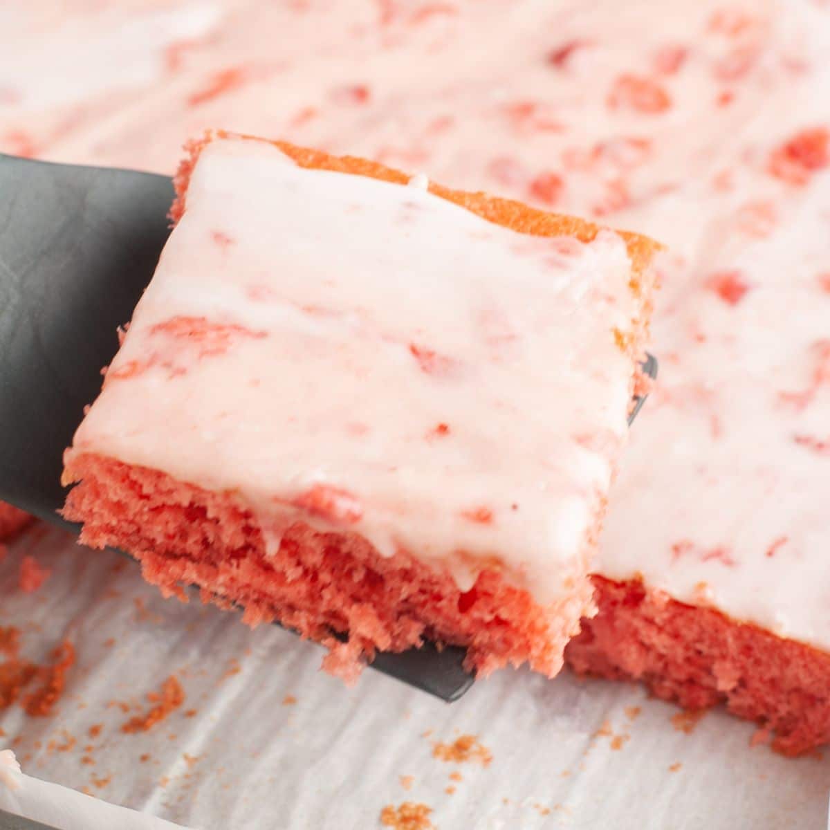 Spatula with a piece of strawberry sheet cake.
