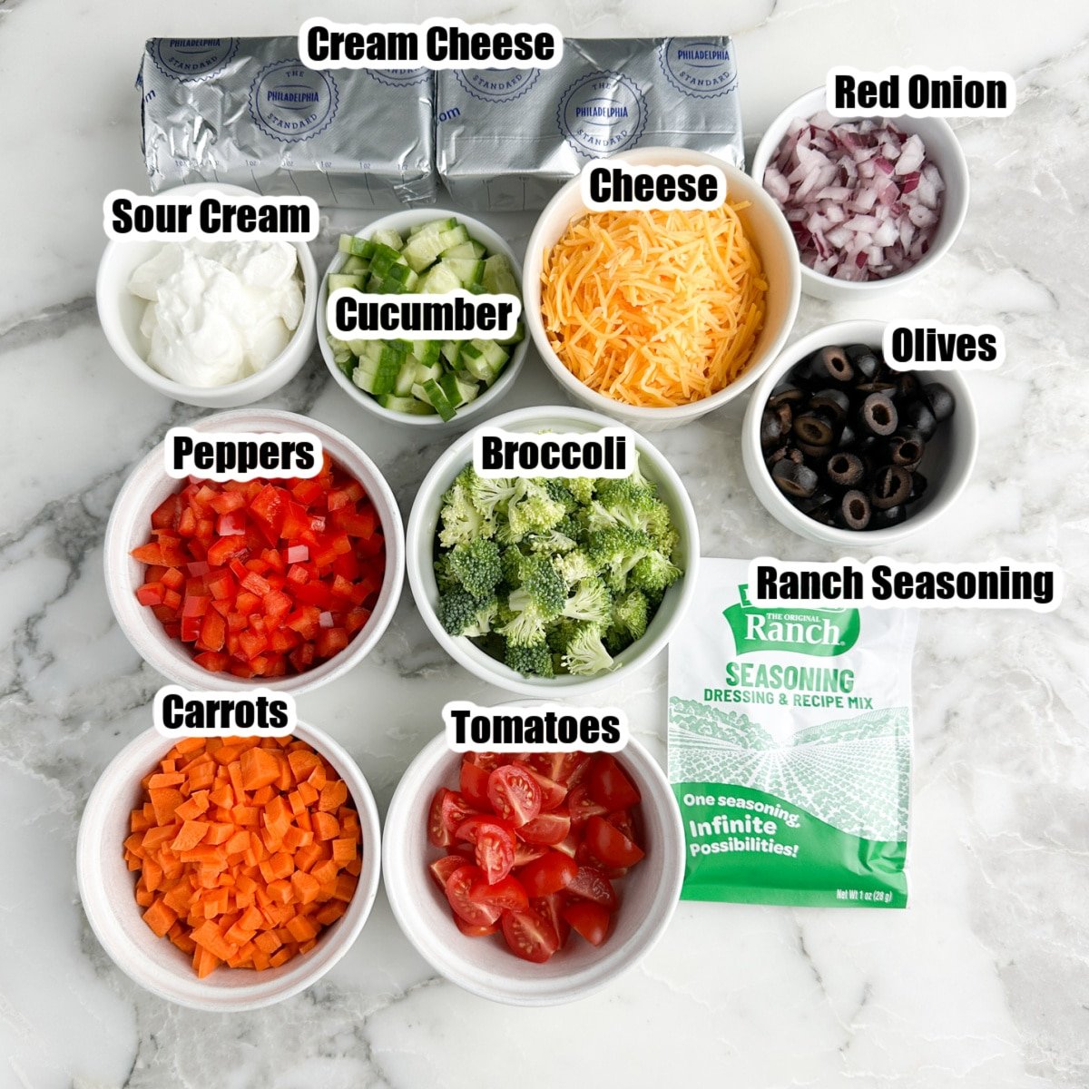 Cream cheese, bowl of sour cream, ranch seasoning, bowls of diced vegetables.