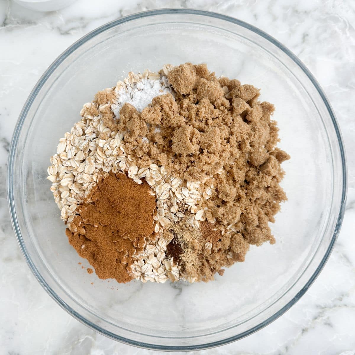 Bowl of oatmeal, brown sugar, spices, and baking powder.