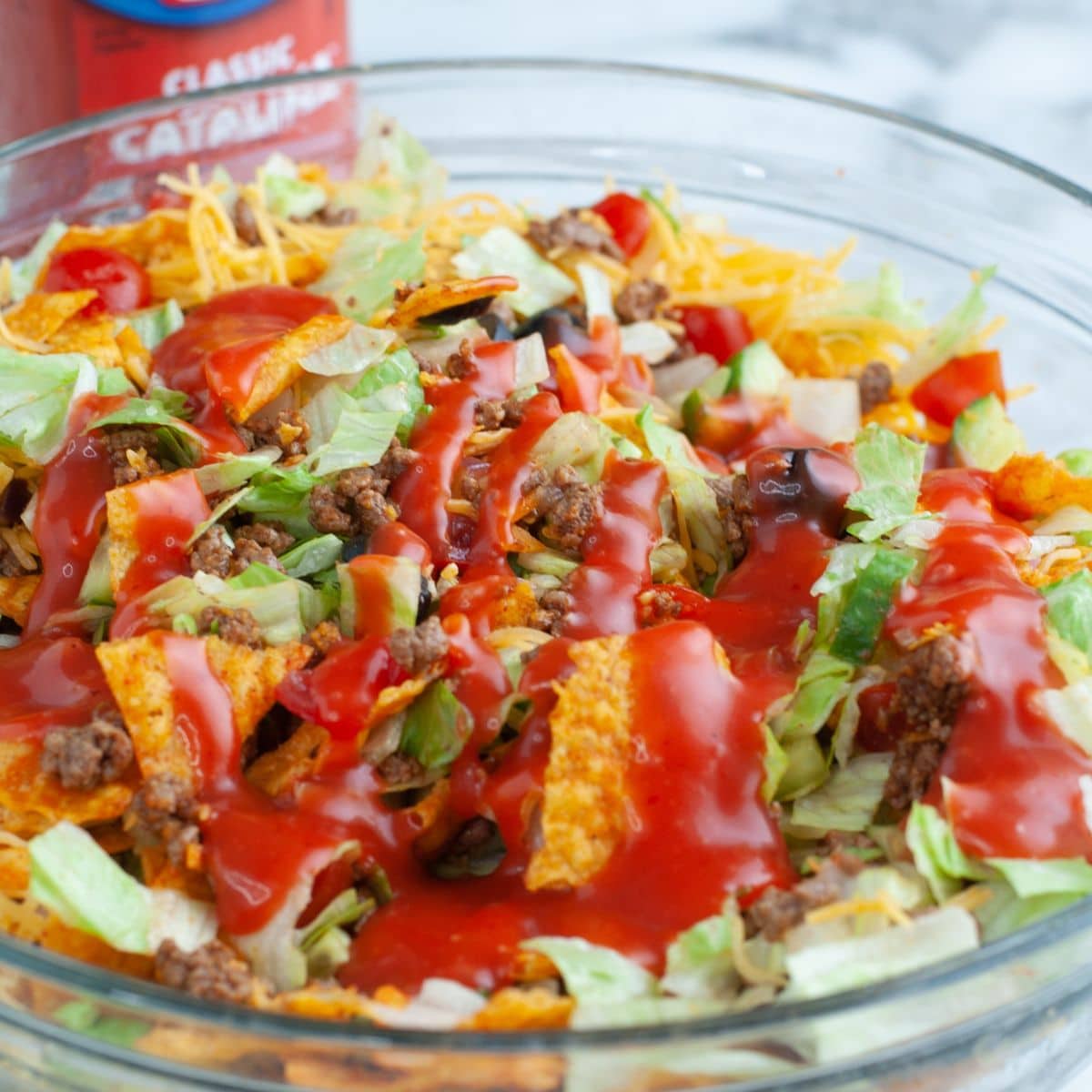 Bowl of taco salad topped with Catalina dressing.