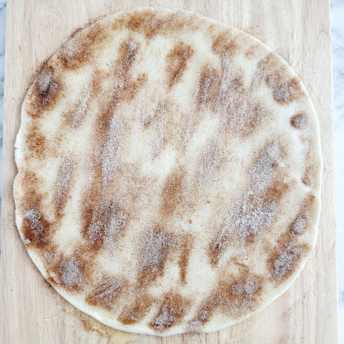 Unbaked pie crust topped with cinnamon and sugar.