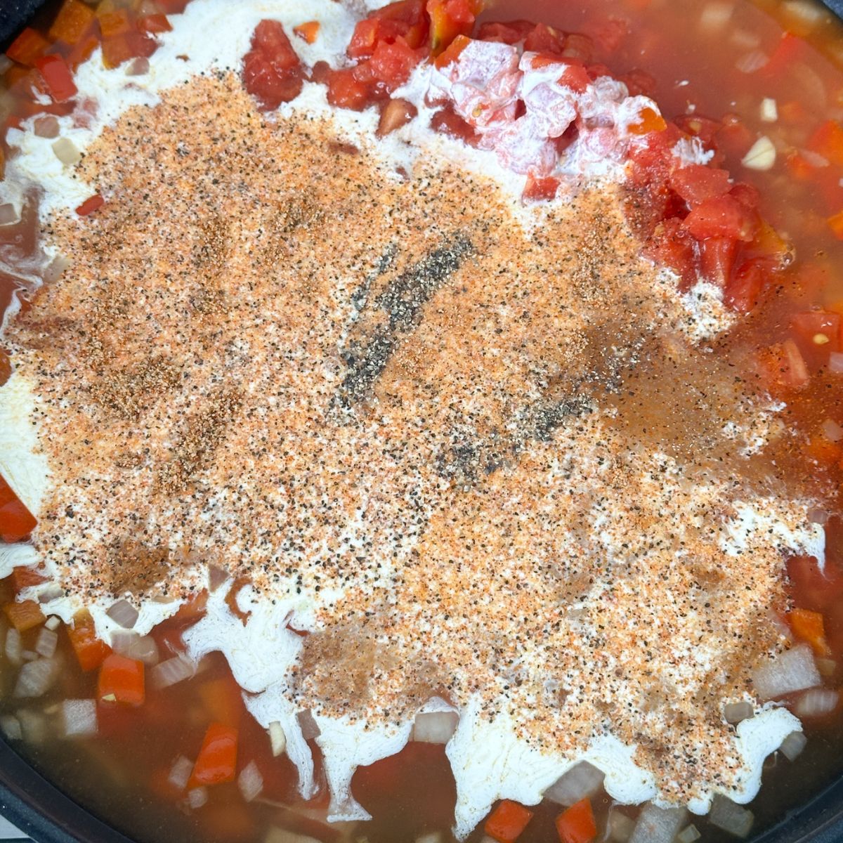 Skillet with diced tomatoes, cream, and seasonings.