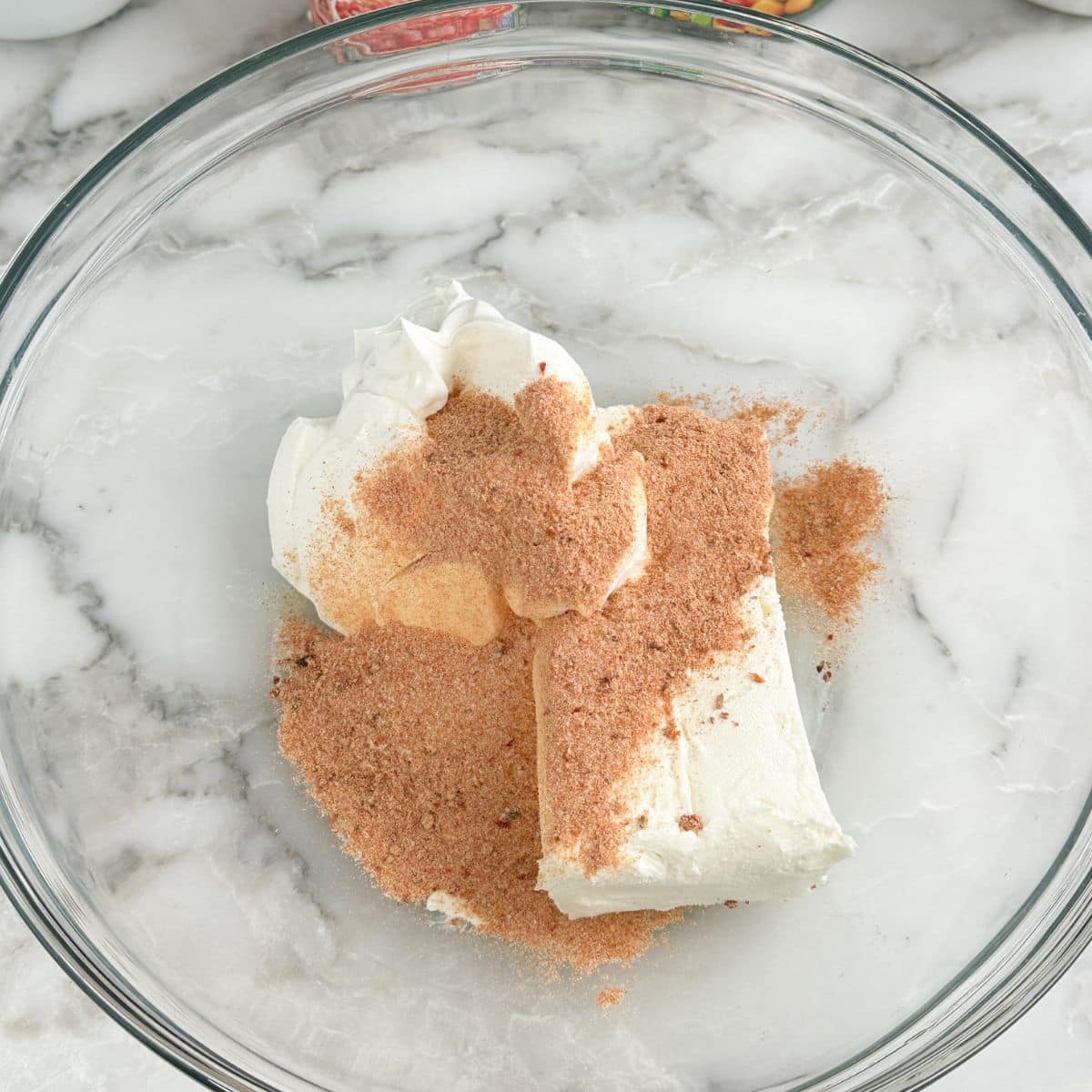 Bowl of cream cheese, sour cream, and ranch seasonings. 