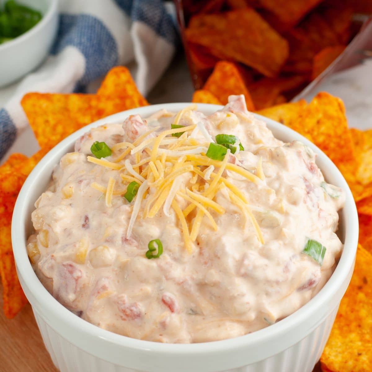 Bowl of Doritos dip topped with shredded cheese. 