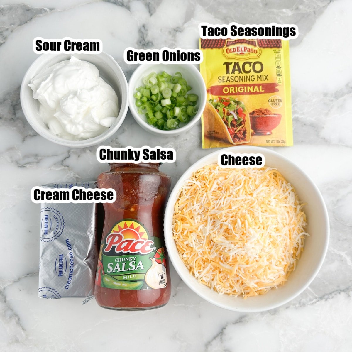 Jar of salsa, bowl of sour cream, cream cheese, taco seasonings, cheese, and green onions.