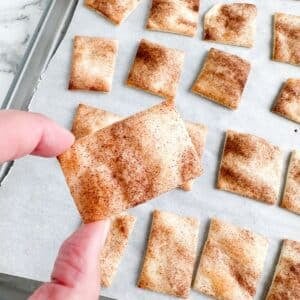 Hand holding cinnamon pie chip.