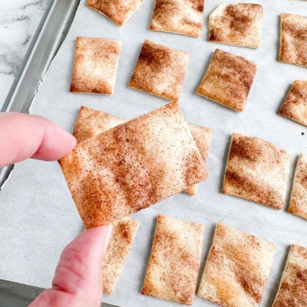 Hand holding cinnamon pie chip.