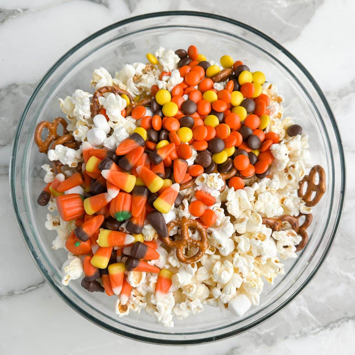 Bowl of popcorn, pretzels, and candy.