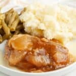 Plate with apple pie pork chop, mashed potatoes, and green beans.