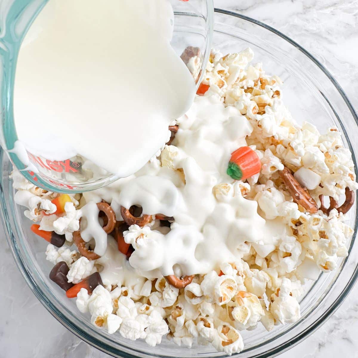 Bowl of popcorn, candy, and melted white chocolate.