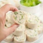 Hand holding a chicken Caesar pinwheel.