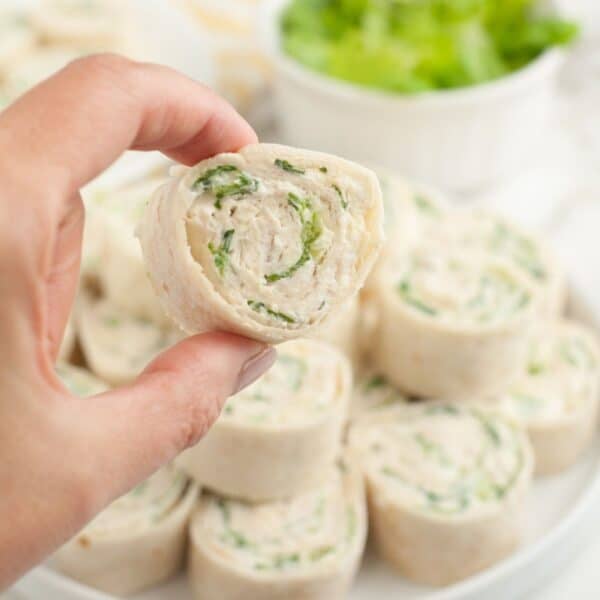 Hand holding a chicken Caesar pinwheel.