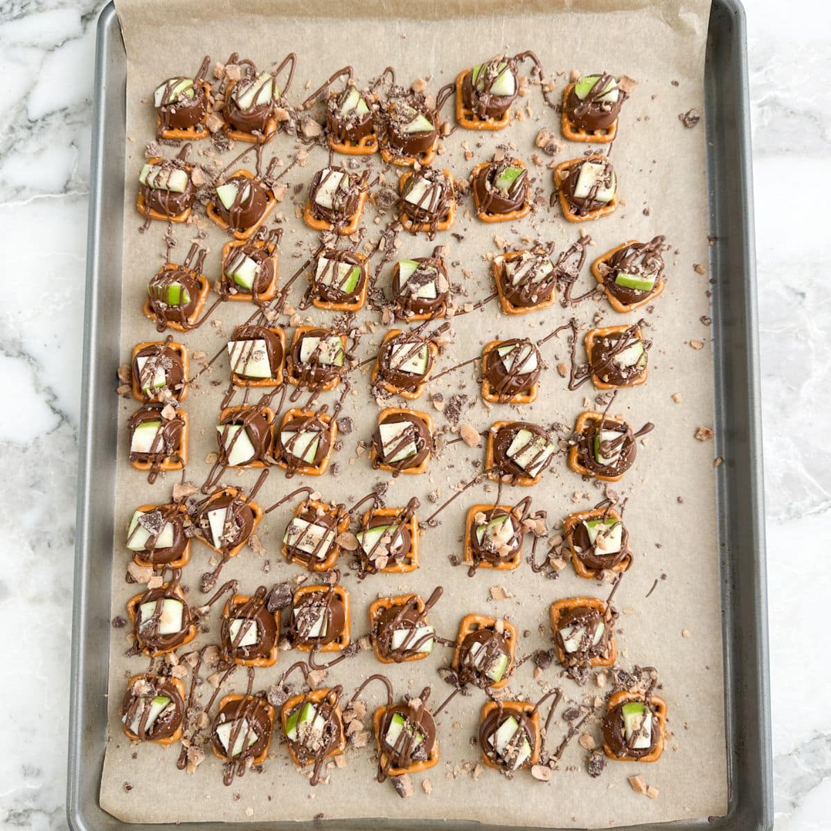Baking pan with pretzels caramel apple pretzel bites made with Rolo candy.