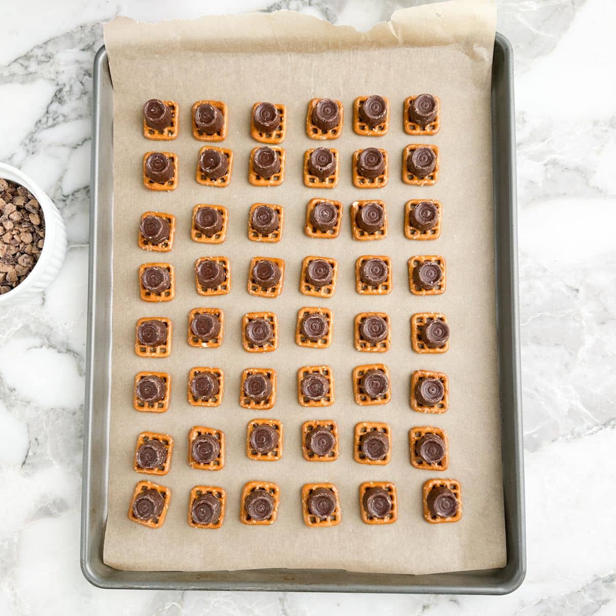 Baking pan with pretzels topped with Rolo candy.