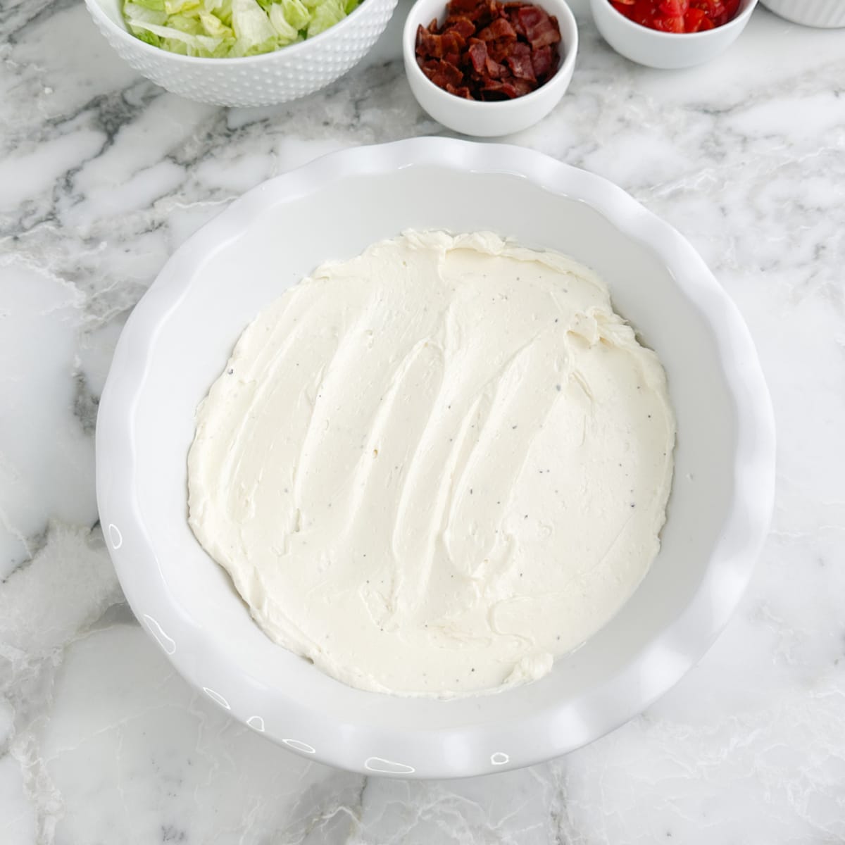 Serving dish with cream cheese spread in the bottom.