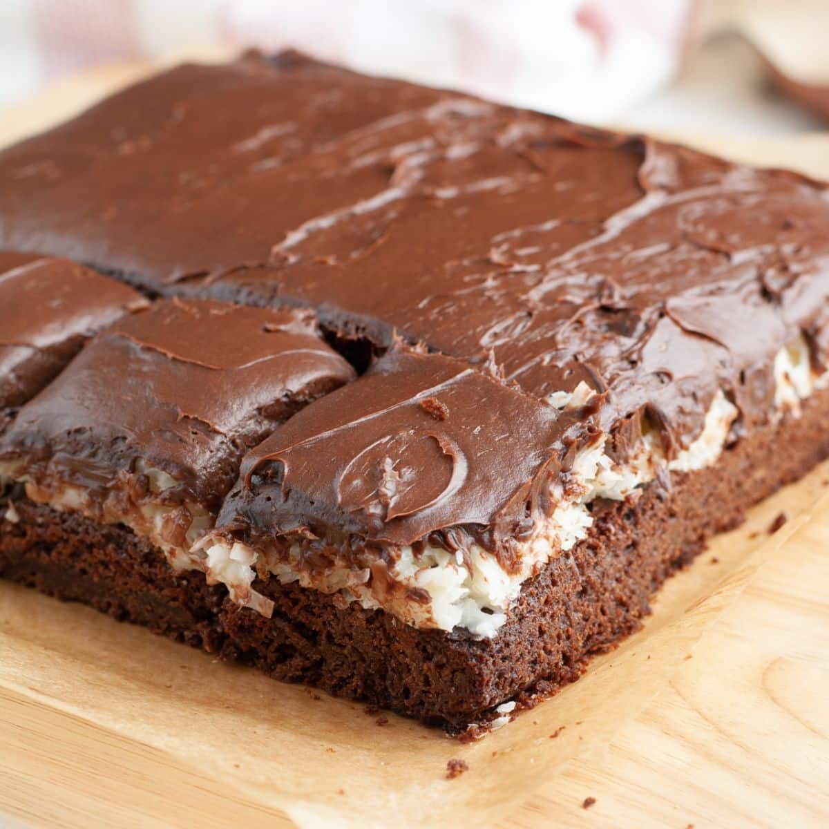 Coconut brownies on a cutting board. 