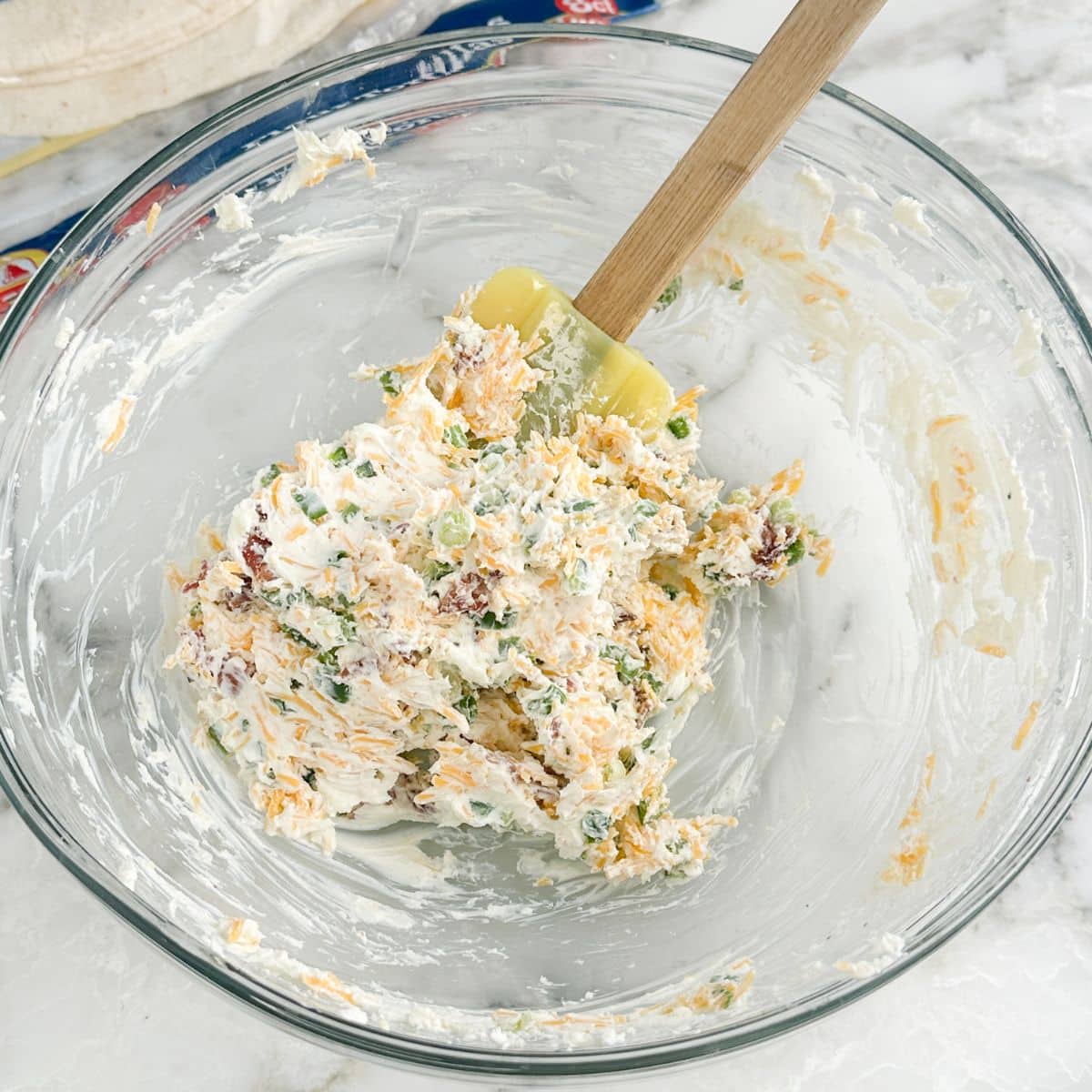 Bowl of mixed cream cheese, bacon, and jalapenos.