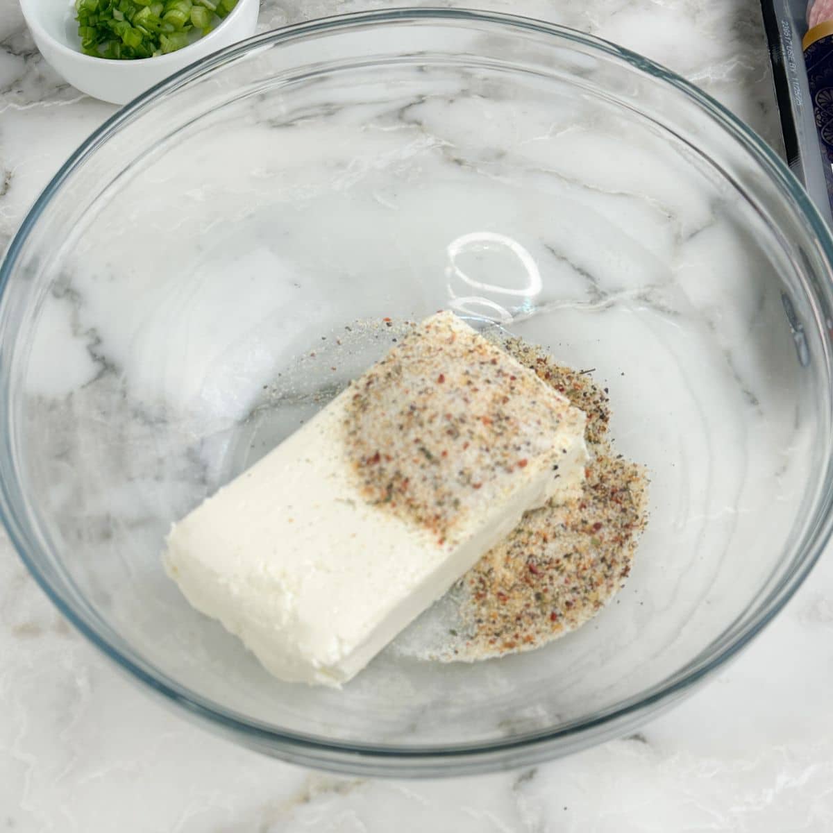 Bowl of cream cheese and Italian seasoning.