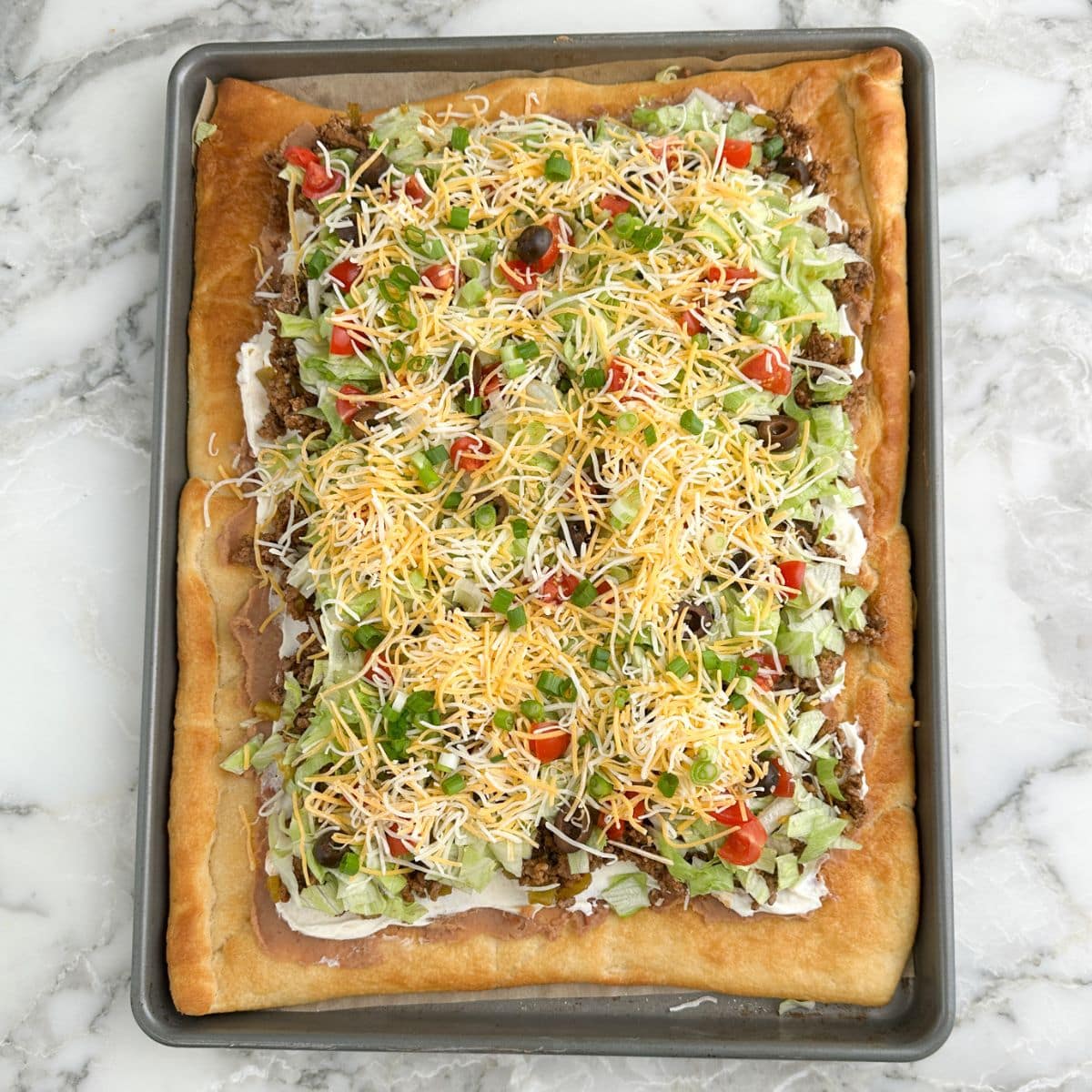 Crescent roll taco pizza on a pan. 