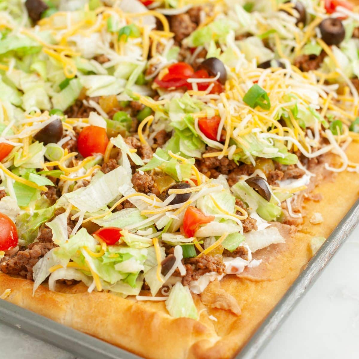 Crescent roll taco pizza on a pan.