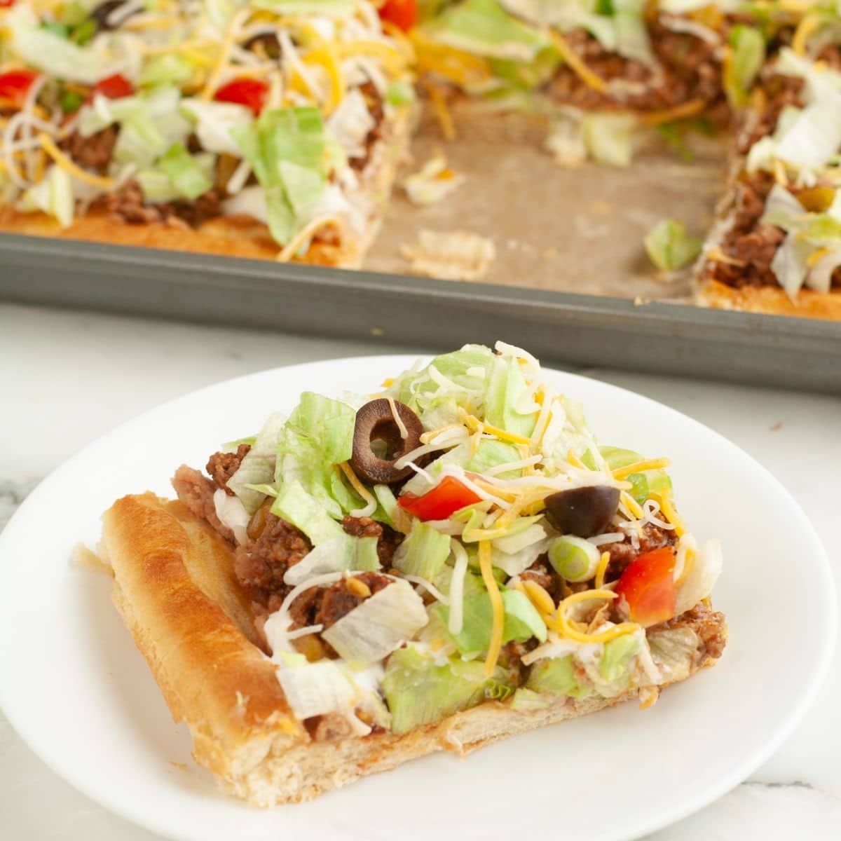 Plate with a piece or crescent roll taco pizza.