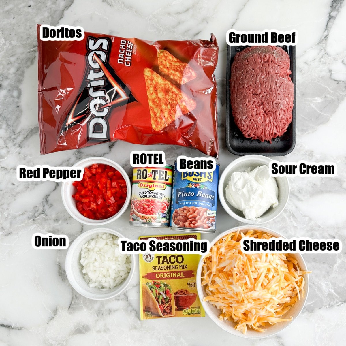 Bag of Doritos, ground beef, can of beans, Rotel, sour cream, cheese, peppers, onions, and taco seasoning.