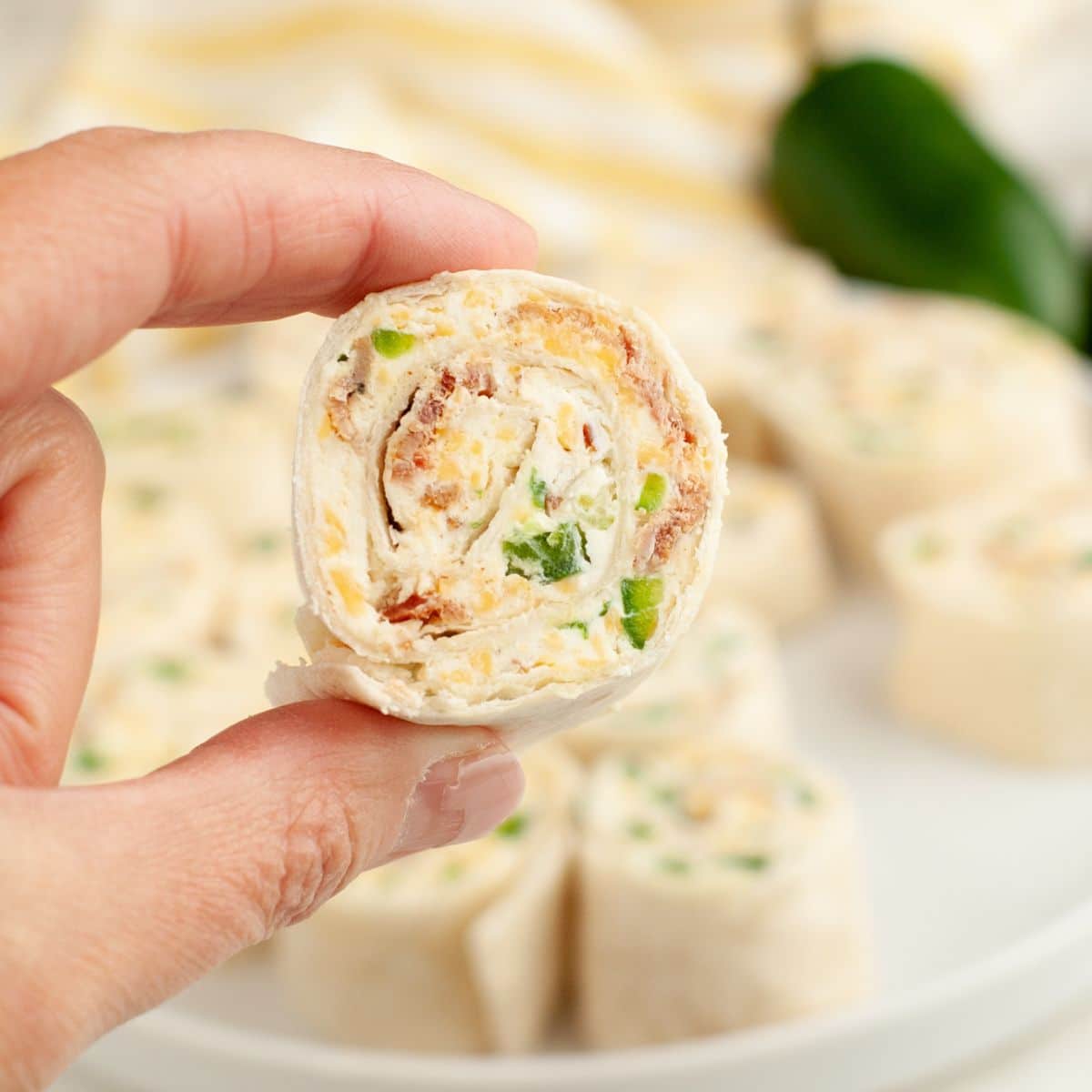 Hand holding a jalapeno popper pinwheel.