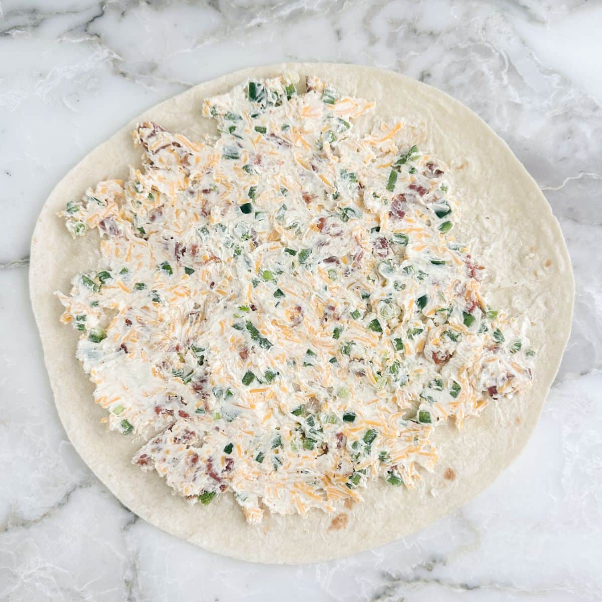 Flour tortilla topped with a cream cheese mixture.