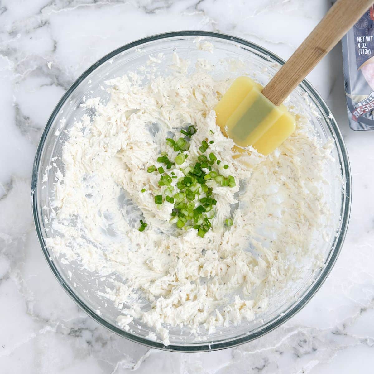 Bowl of cream cheese with diced green onions.