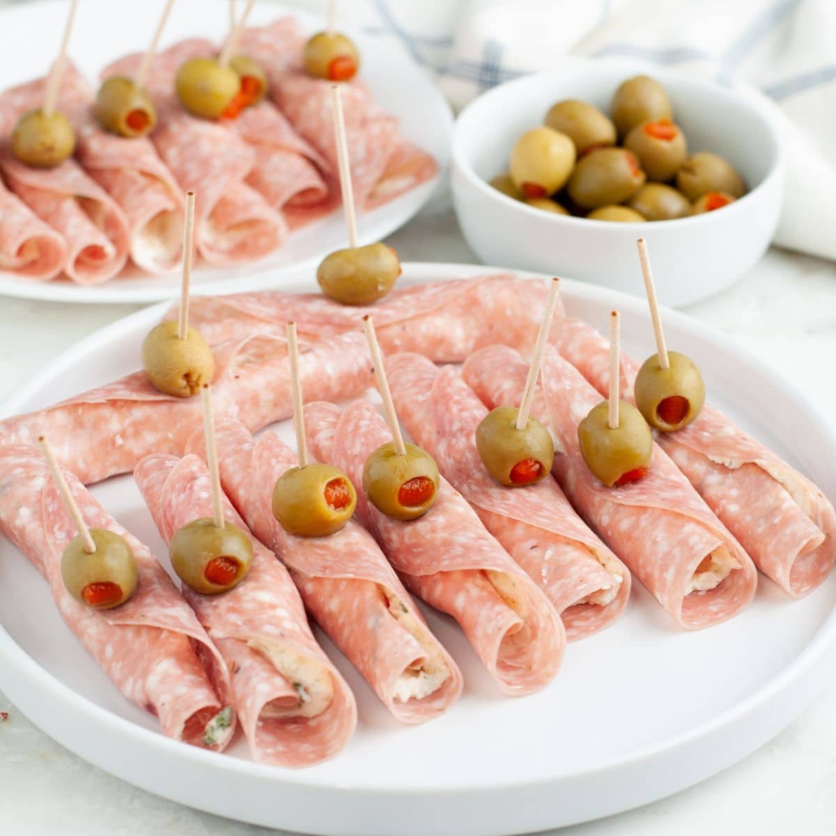 Plate of salami roll ups.