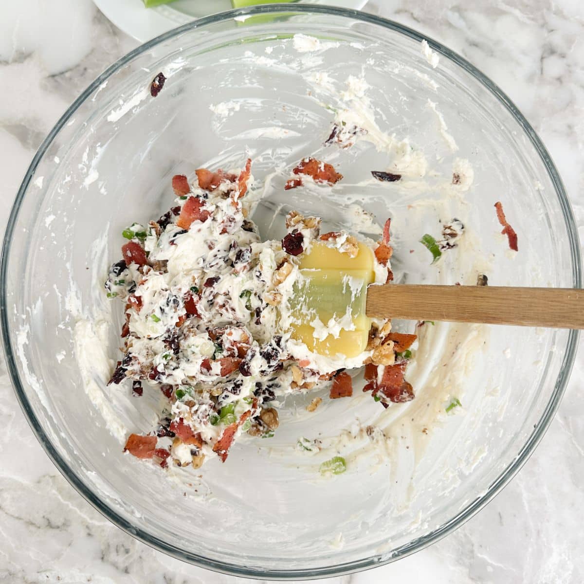 Bowl with cream cheese, chopped bacon, green onion, and cranberries.