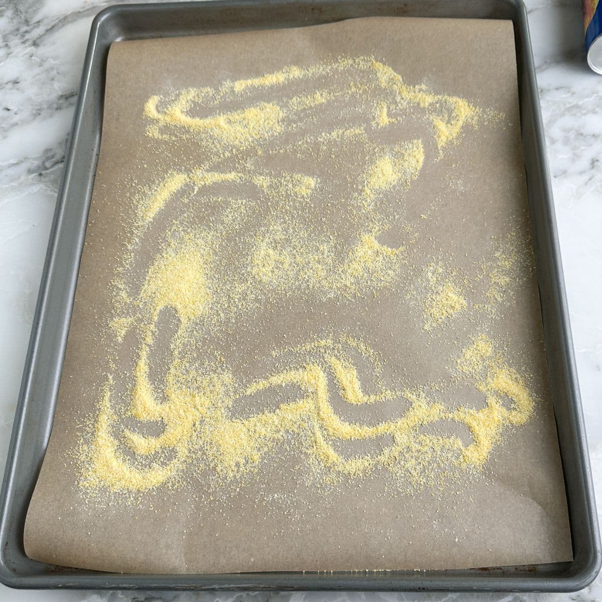 Baking pan with parchment and cornmeal. 