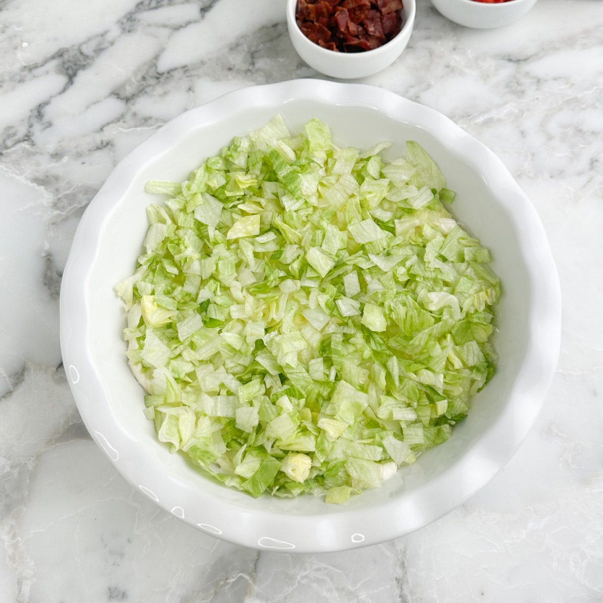 Serving dish with cream cheese and chopped lettuce.