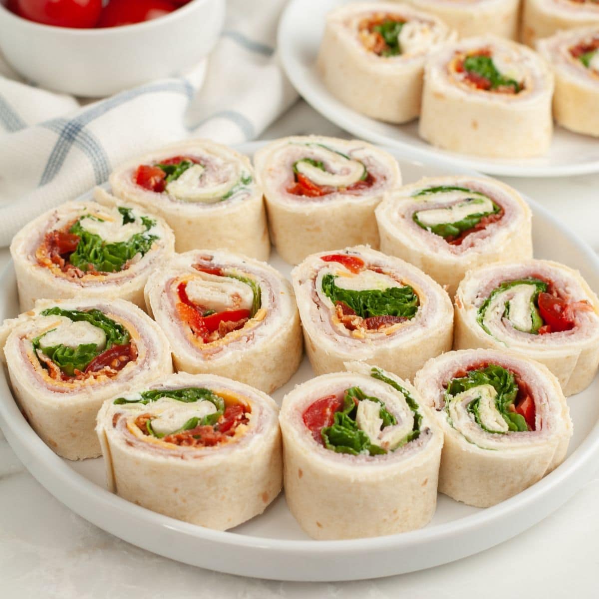 Plate of club sandwich tortilla roll ups.