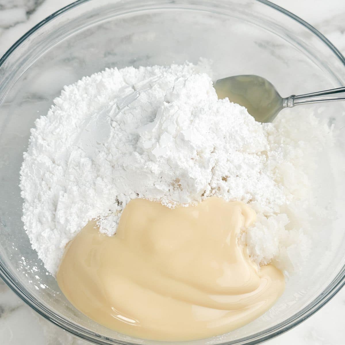 Bowl with coconut, powdered sugar, and sweetened condensed milk.