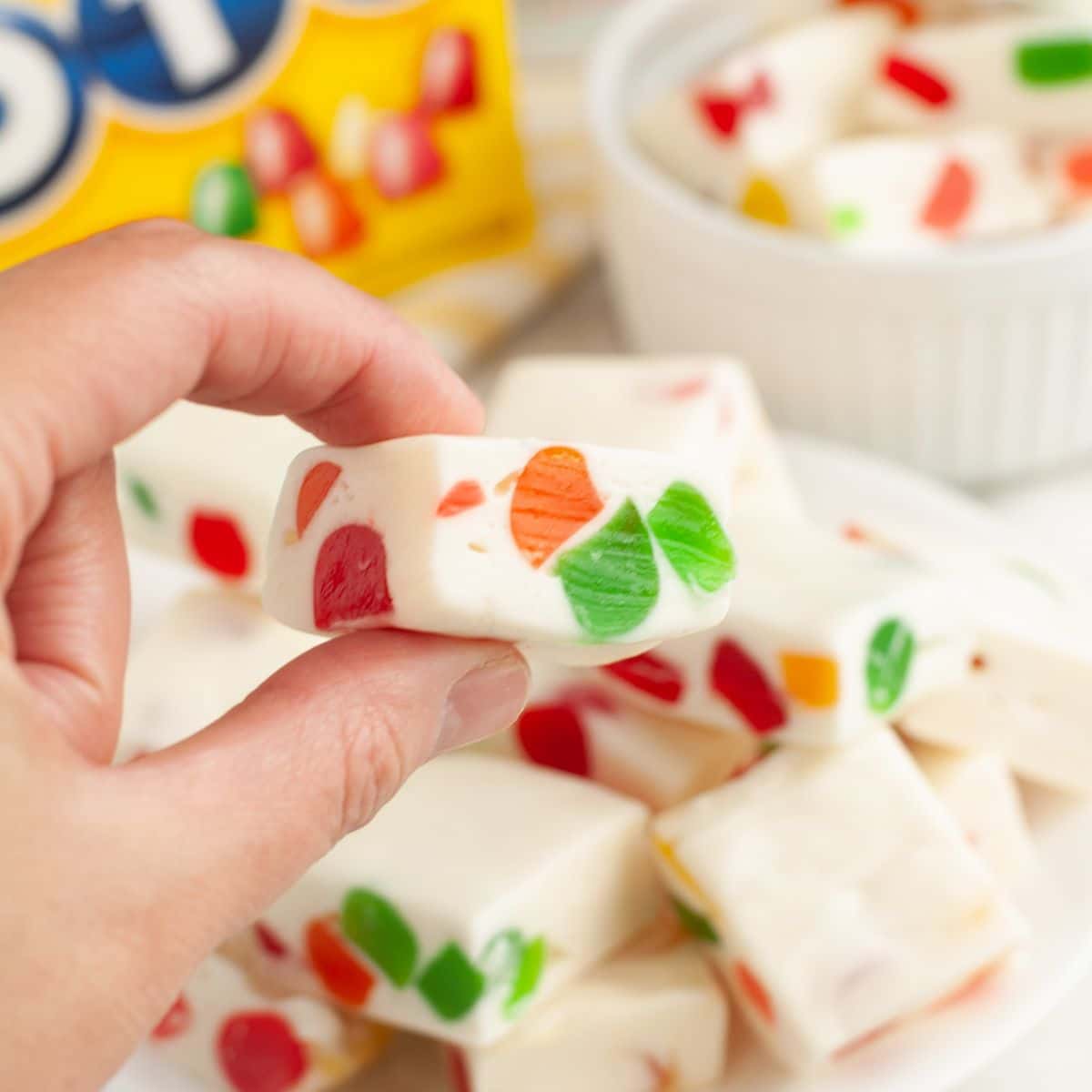 Hand holding a piece of nougat candy. 