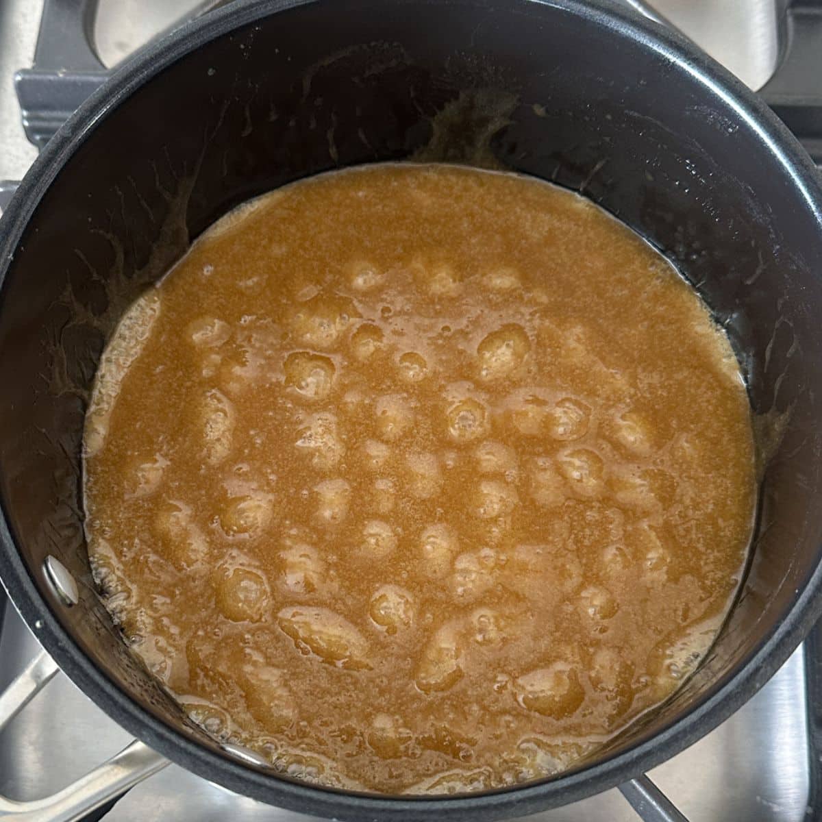 Saucepan with bubbling caramel sauce.