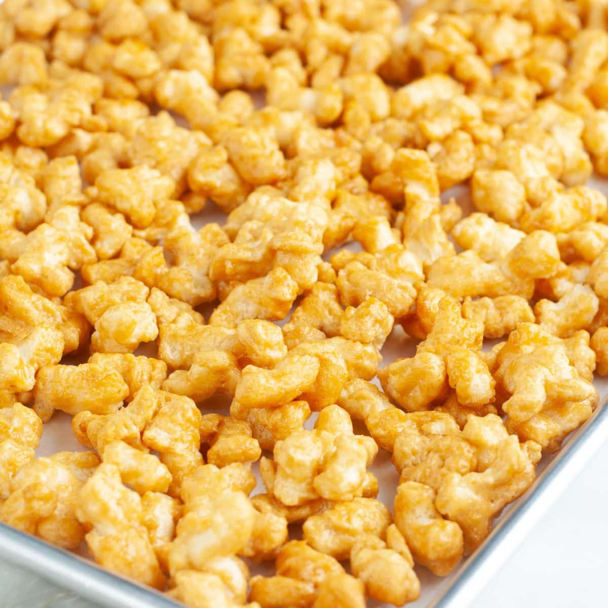 Caramel puffcorn on a baking pan. 