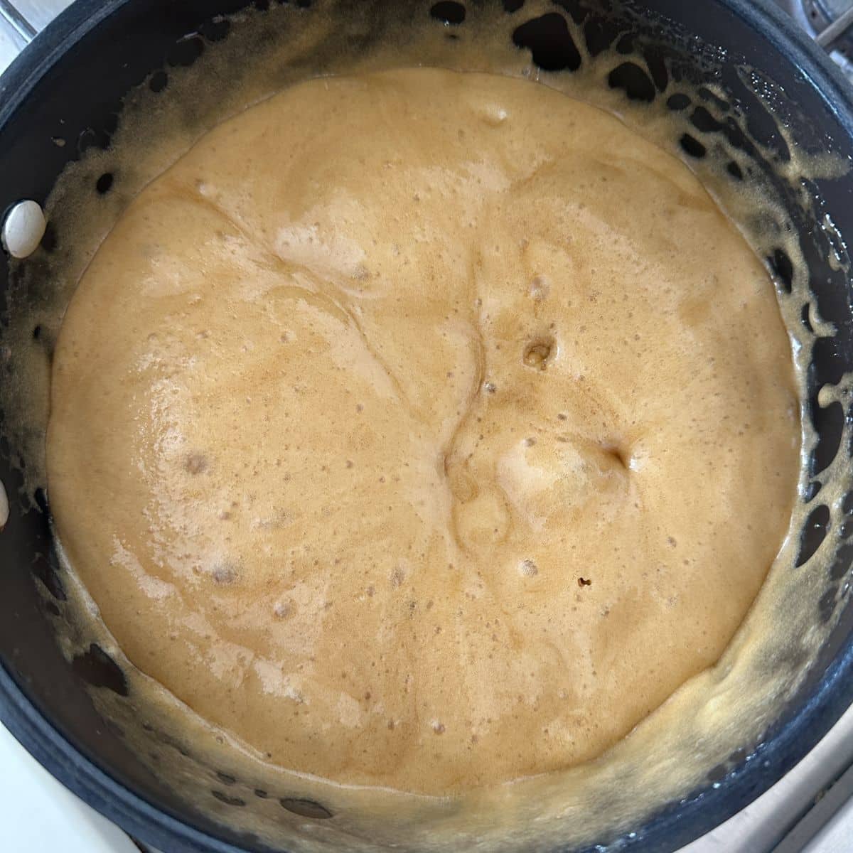 Saucepan with bubbling caramel. 