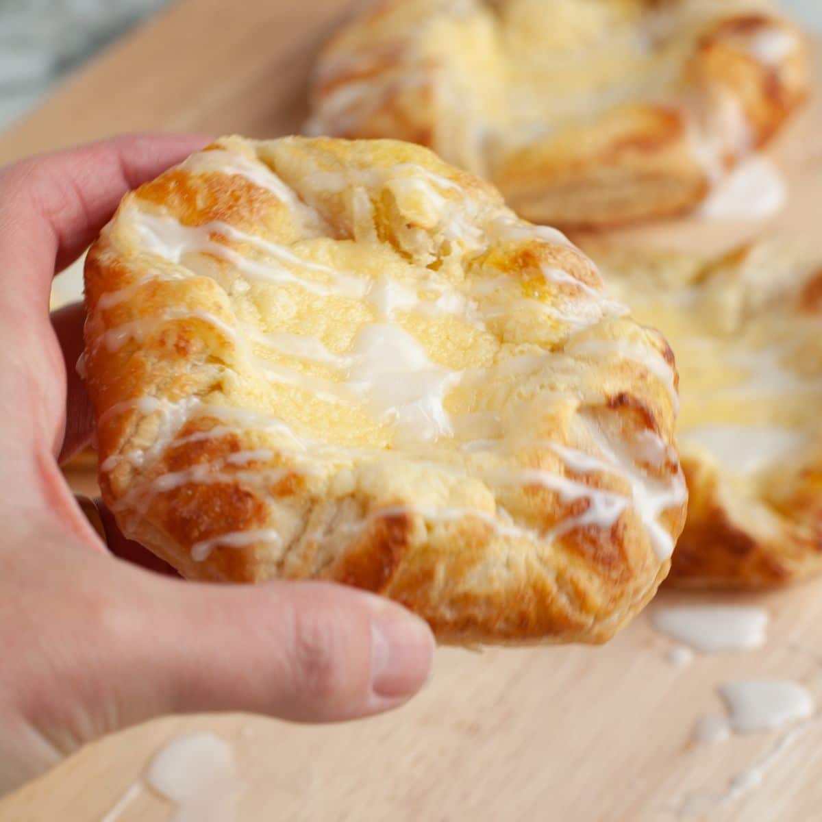 Hand holding a cream cheese danish.