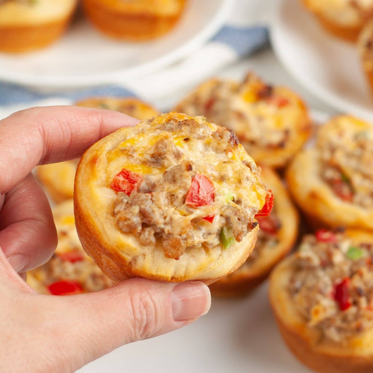 Hand holding a cream cheese sausage bites.