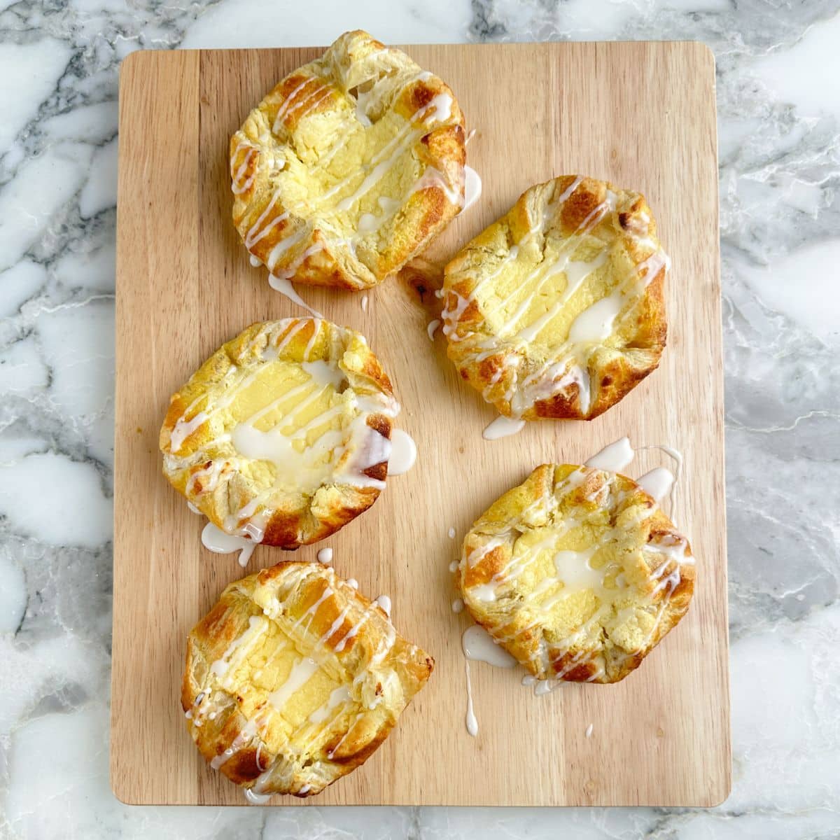Cutting board with cream cheese danish.