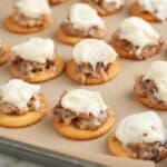 Pan with Ritz crackers topped with pecans and frosting.