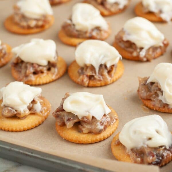 Pan with Ritz crackers topped with pecans and frosting.