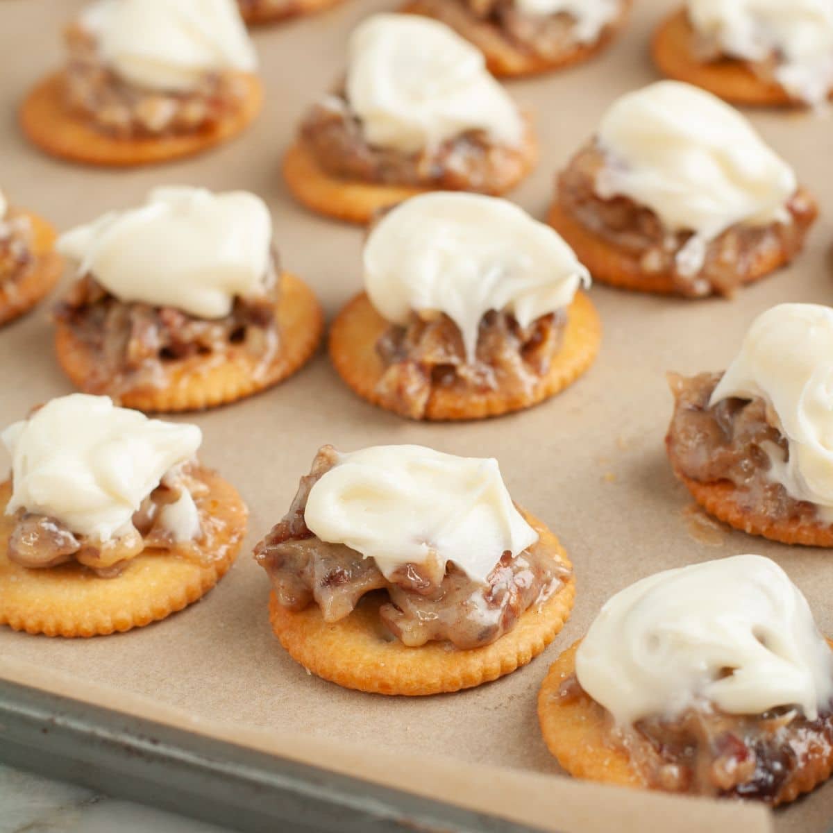 Pan with Ritz crackers topped with pecans and frosting. 